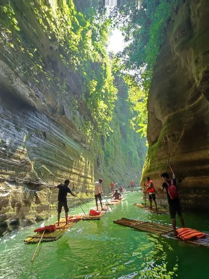 Travellers on bamboo rafts in the narrow gorge of Debotakhum