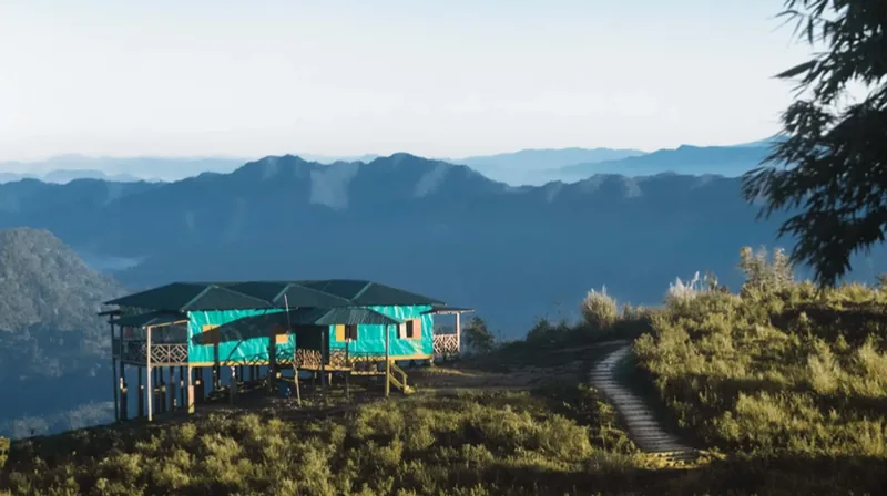 A wooden cottage on a Sajek hilltop at dusk